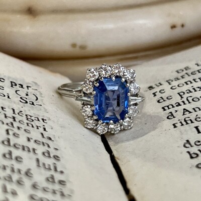 Bague Marguerite en or blanc, saphir de taille émeraude de 2,80 carats, diamants troidia pour 0,20 carat et diamants pour 0,60 carat