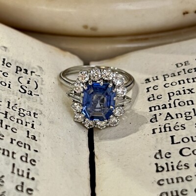 Bague Marguerite en or blanc, saphir de taille émeraude de 2,80 carats, diamants troidia pour 0,20 carat et diamants pour 0,60 carat