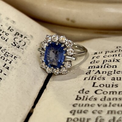 Bague Marguerite en or blanc, saphir de taille émeraude de 2,80 carats, diamants troidia pour 0,20 carat et diamants pour 0,60 carat