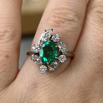 Bague en or blanc, or jaune, émeraude de taille ovale de 1,20 carat, diamants de taille marquise pour 0,80 carat et diamants pour 0,40 carat