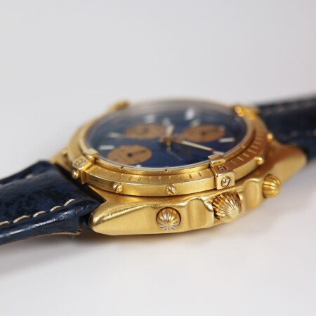 Montre Breitling Chronomat vintage automatique or jaune cadran bleu compteurs dorés bracelet cuir bleu 39mm