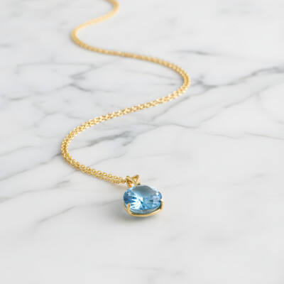 Pendentif or jaune et topaze bleue