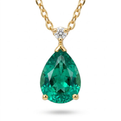 Collier or jaune, émeraude poire et diamants