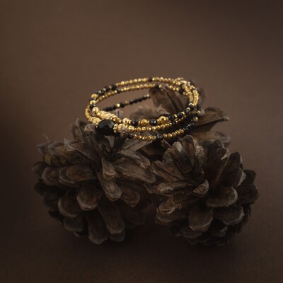 Le bracelet Tuna en pierres naturelles noires et dorées
