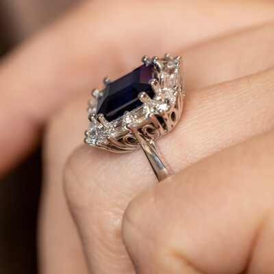 Bague en or blanc avec saphir bleu taille émeraude et entourage de diamants