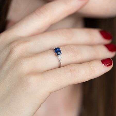 Bague en or blanc centrée sur un saphir de Ceylan radiant serti à quatre griffes avec diamants en taille poire