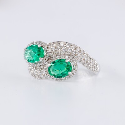 Bague en or blanc centre deux pierres émeraudes de taille ovale accompagnées de diamants
