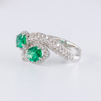 Bague en or blanc centre deux pierres émeraudes de taille ovale accompagnées de diamants