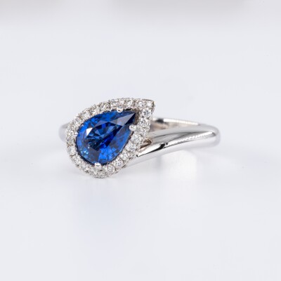 Bague en or blanc centre saphir bleu taille poire accompagnées de diamants taille brillant
