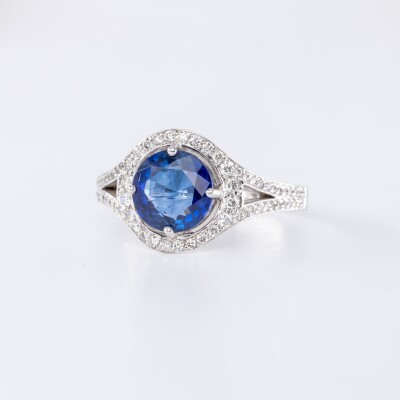 Bague en or blanc centre saphir bleu taille brillant accompagné de diamants