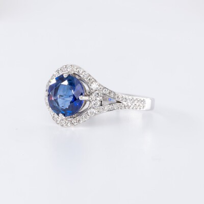 Bague en or blanc centre saphir bleu taille brillant accompagné de diamants