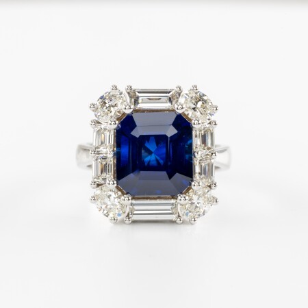 Bague en or blanc avec saphir bleu taille émeraude et entourage de diamants