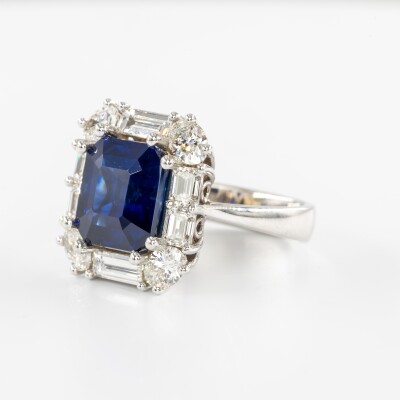 Bague en or blanc avec saphir bleu taille émeraude et entourage de diamants