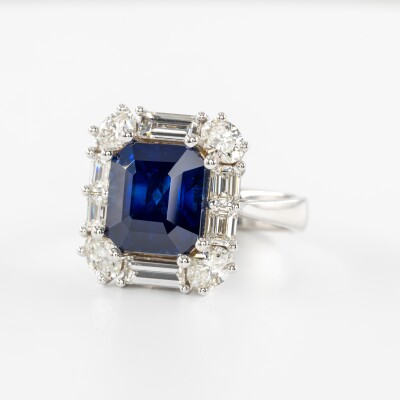 Bague en or blanc avec saphir bleu taille émeraude et entourage de diamants