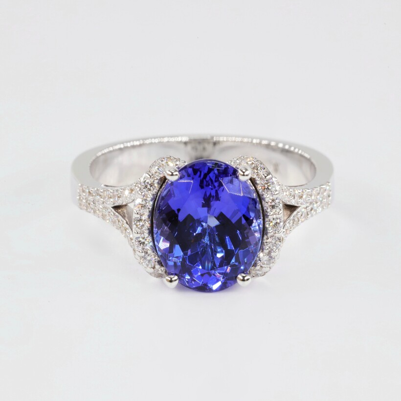 Bague en or blanc centre tanzanite ovale sur corps de bague serti de diamants