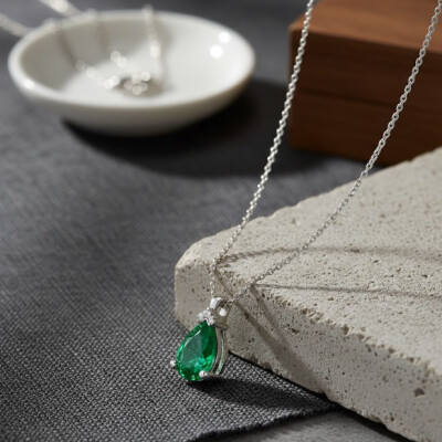 Collier or blanc, émeraude et diamants